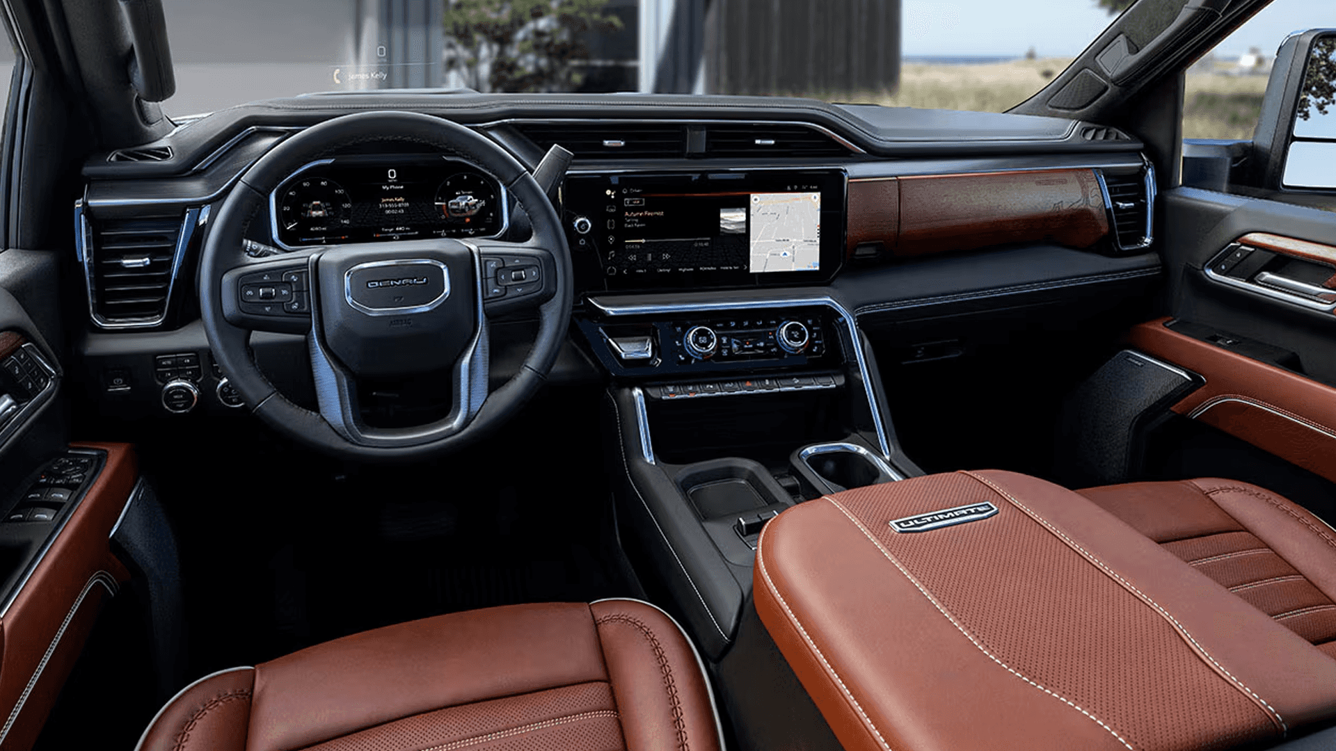 GMC Sierra HD Denali Ultimate interior with brown leather seats, wood trim, large touchscreen, and digital display