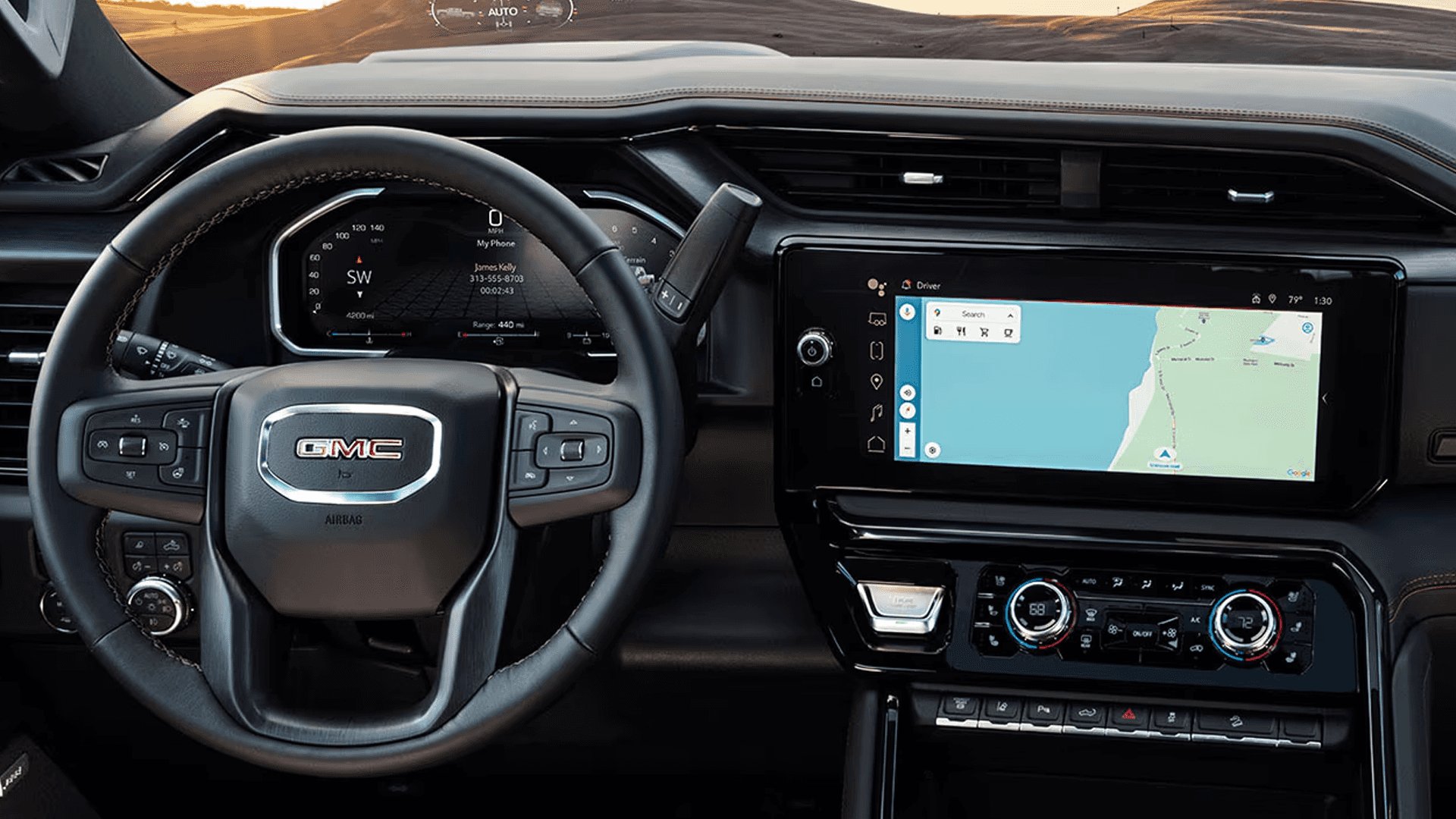 GMC Sierra HD dashboard with steering wheel, digital driver display, wide touchscreen, and climate controls in view