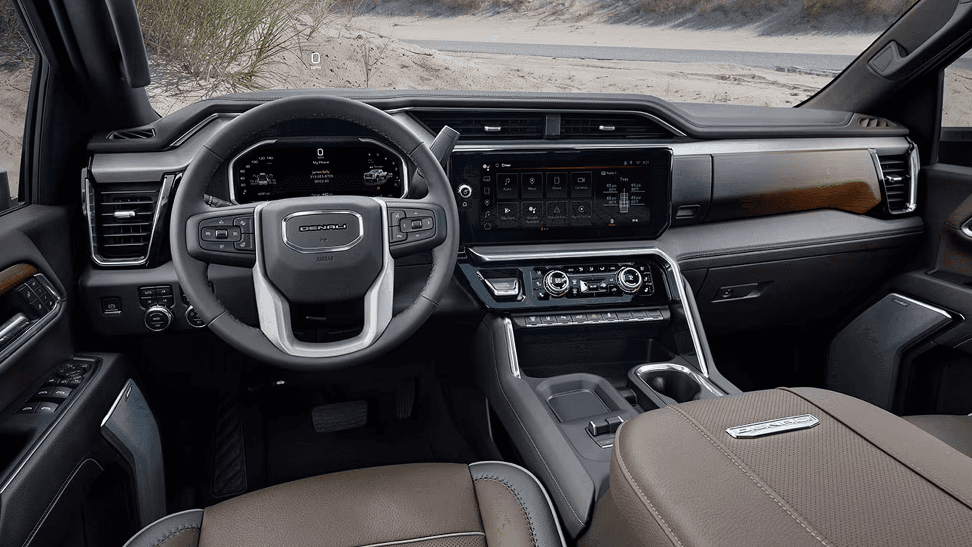 Front cabin overview of the 2026 GMC Sierra HD showing steering wheel, digital driver display, and center touchscreen interface