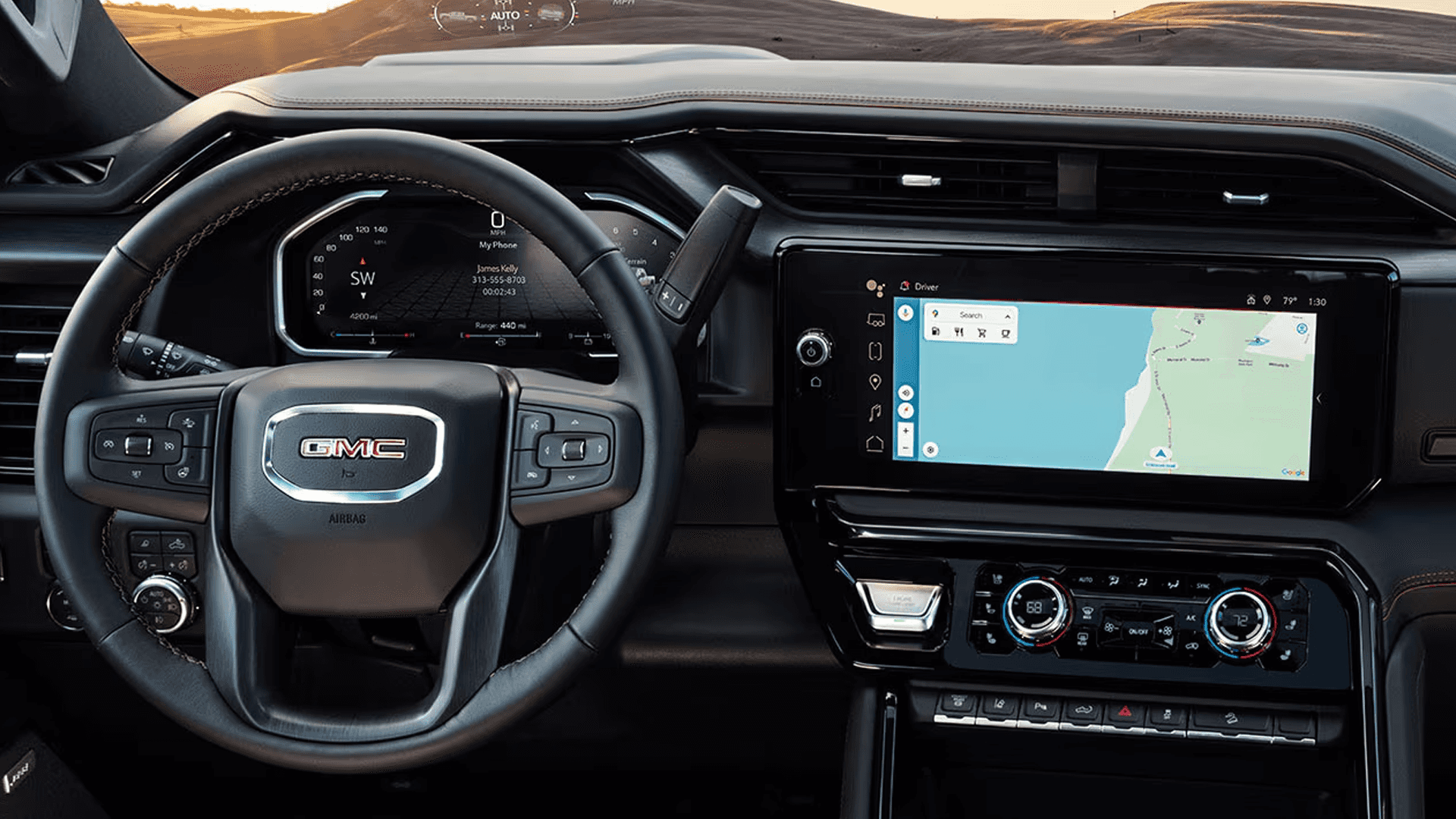 Driver cockpit of the 2026 GMC Sierra HD showing digital gauge cluster, center touchscreen with navigation, and steering wheel controls