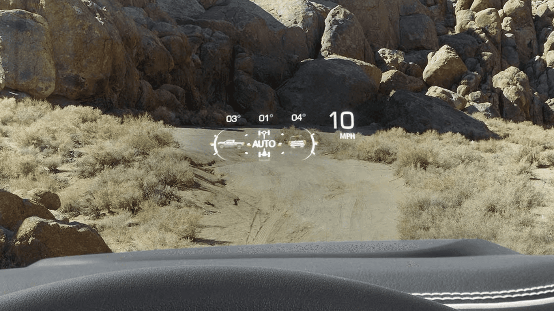 Head-Up Display view in the 2026 GMC Sierra HD showing speed, terrain data, and drive mode information on an off-road trail