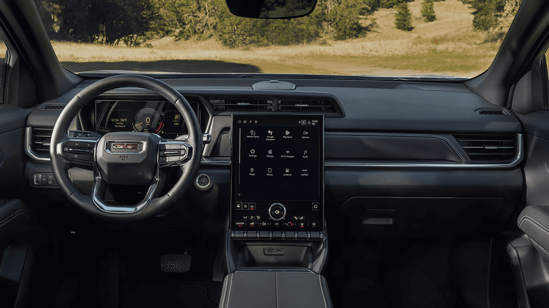 Driver focused GMC Terrain interior with digital gauge cluster, large vertical touchscreen, and steering wheel view.
