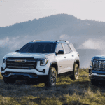 3 GMC Terrain trims sitting on a grassy hill with mountains in the background