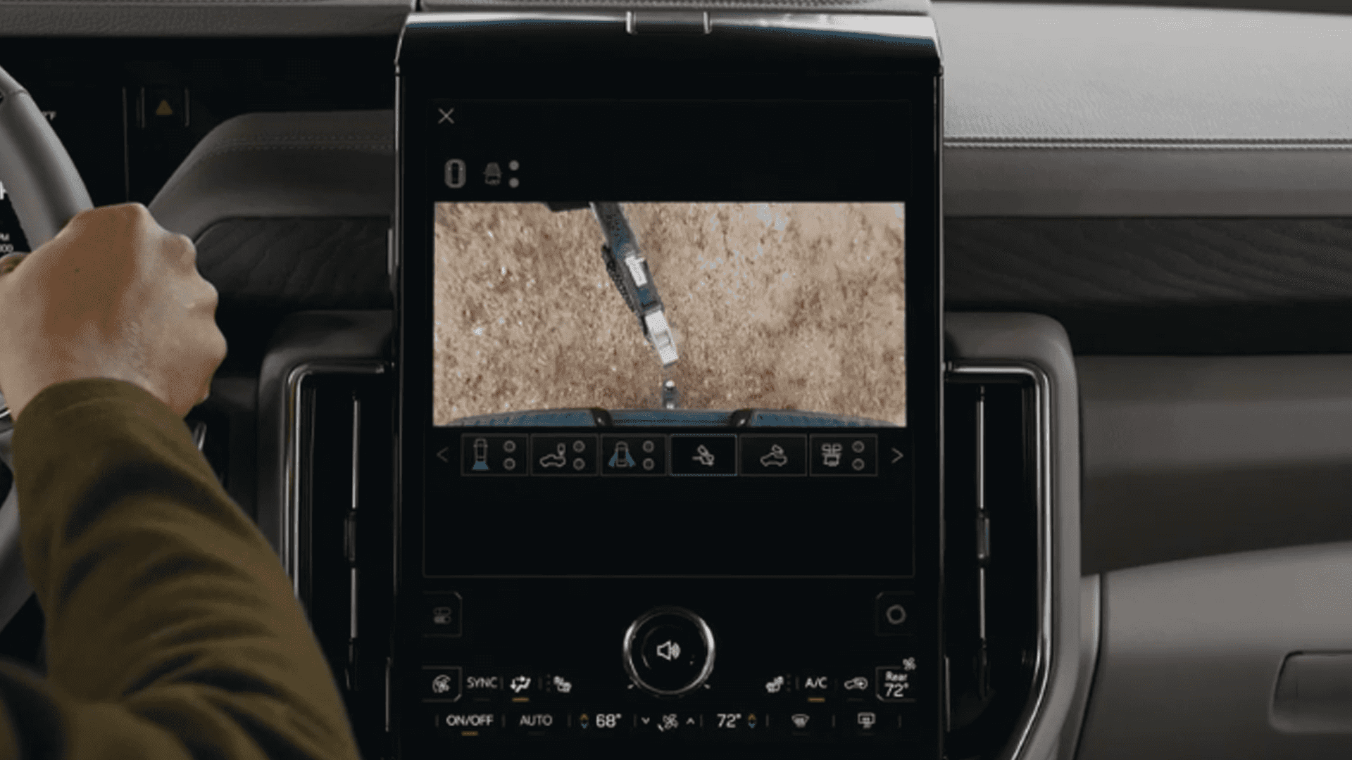 Driver view of a GMC Yukon center screen showing an overhead camera view while aligning a trailer hitch.