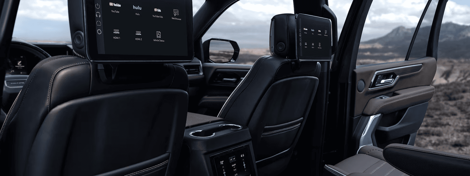 Blue 2026 GMC Yukon parked in desert terrain with LED taillamps, chrome trim, and large alloy wheels.