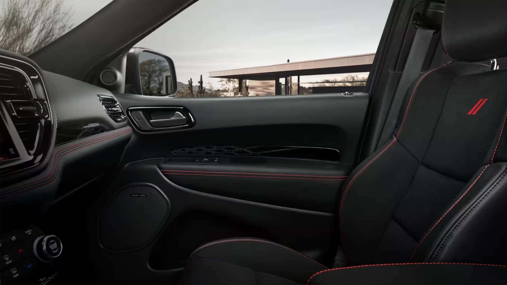2026 Dodge Durango interior showing black leather front seat with red stitching, dashboard trim, and premium cabin materials
