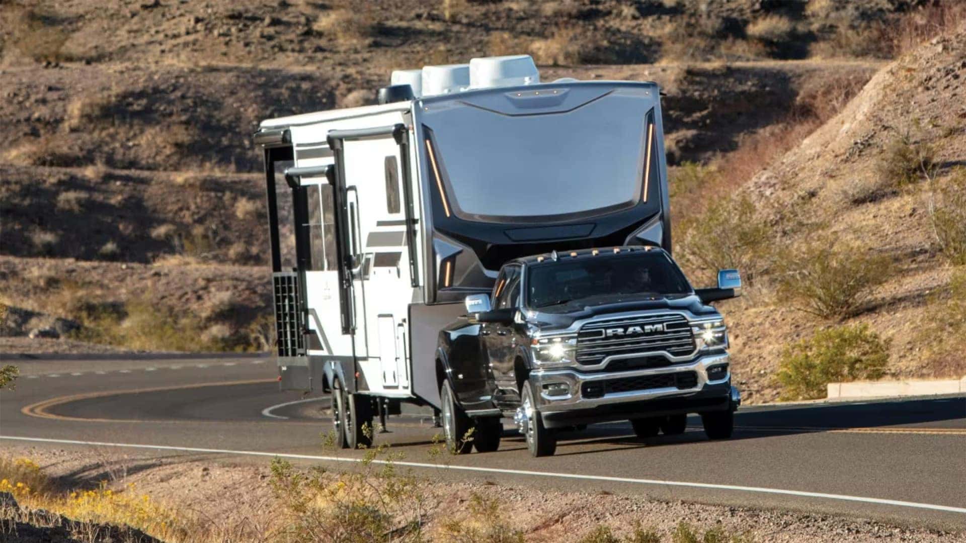 2026 Ram 3500 towing a large fifth-wheel RV on a winding desert road