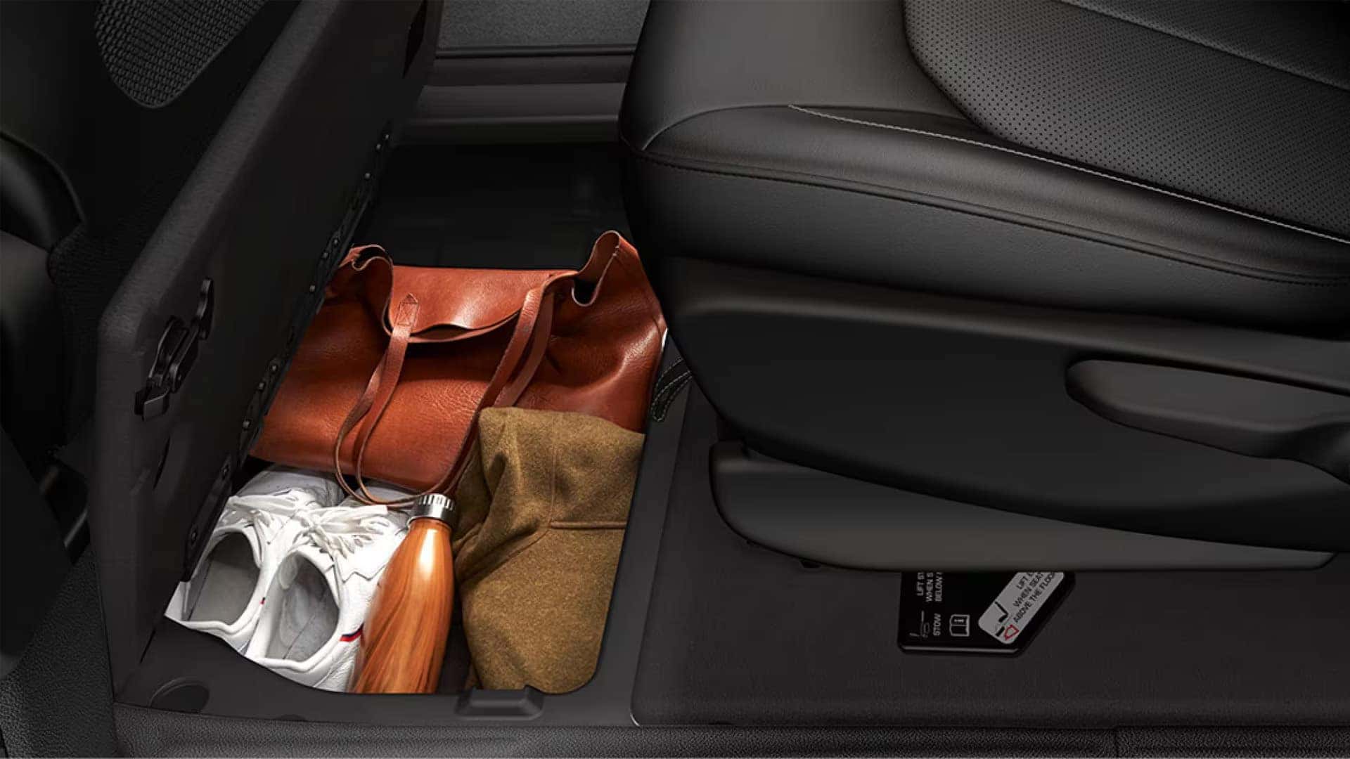 In-floor Stow ’n Go storage compartment in the 2026 Chrysler Voyager holding personal items beneath the second-row seat