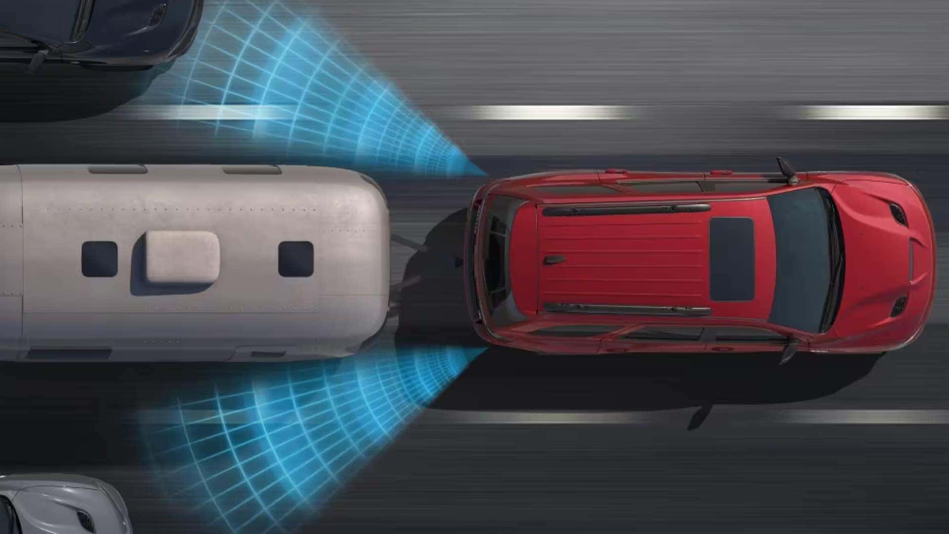 Top-down view of a red 2026 Dodge Durango using driver assistance sensors while towing an Airstream trailer on a highway.