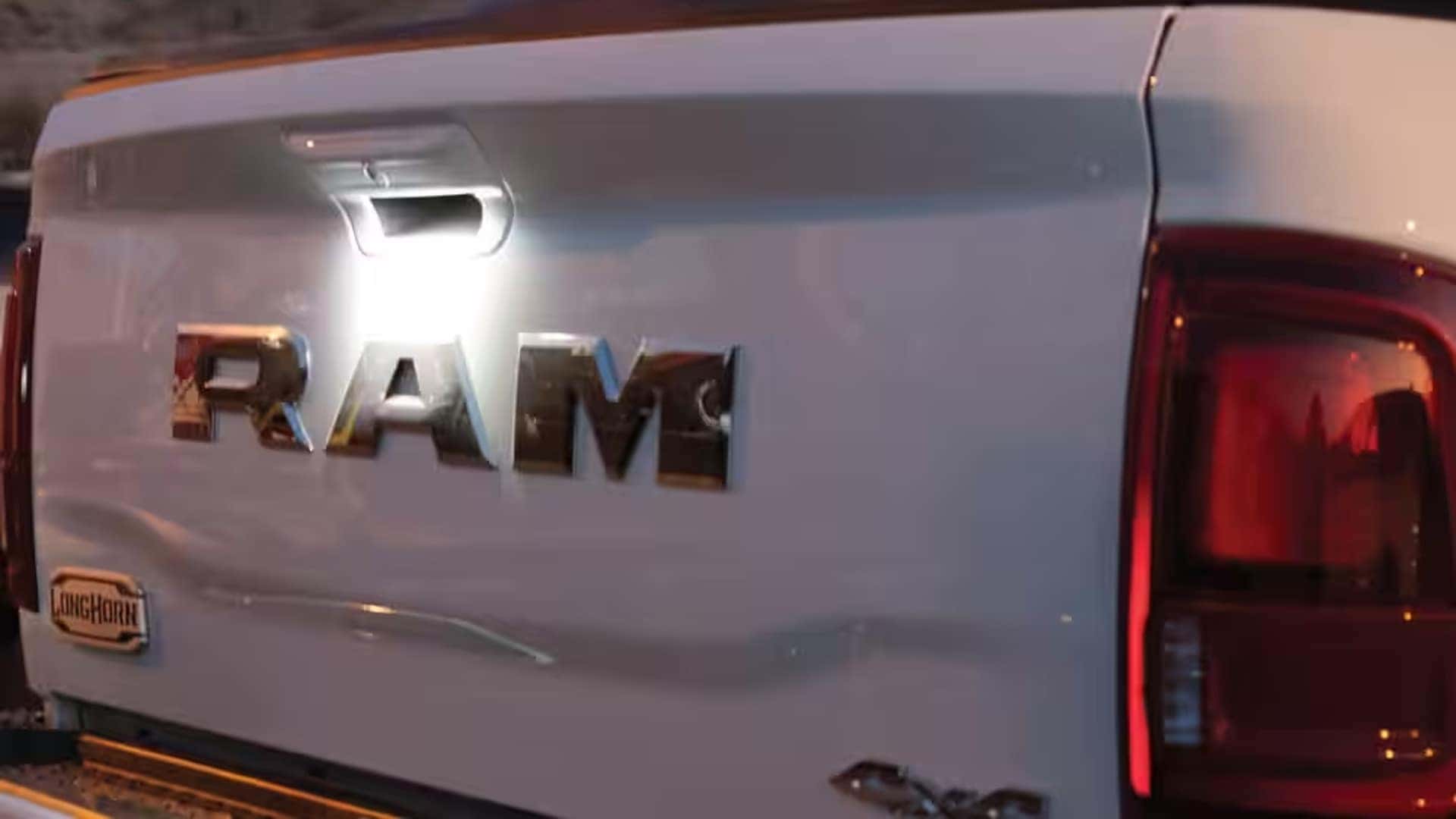 Rear tailgate of a 2026 RAM 2500 Limited Longhorn with RAM badge and illuminated tailgate handle light