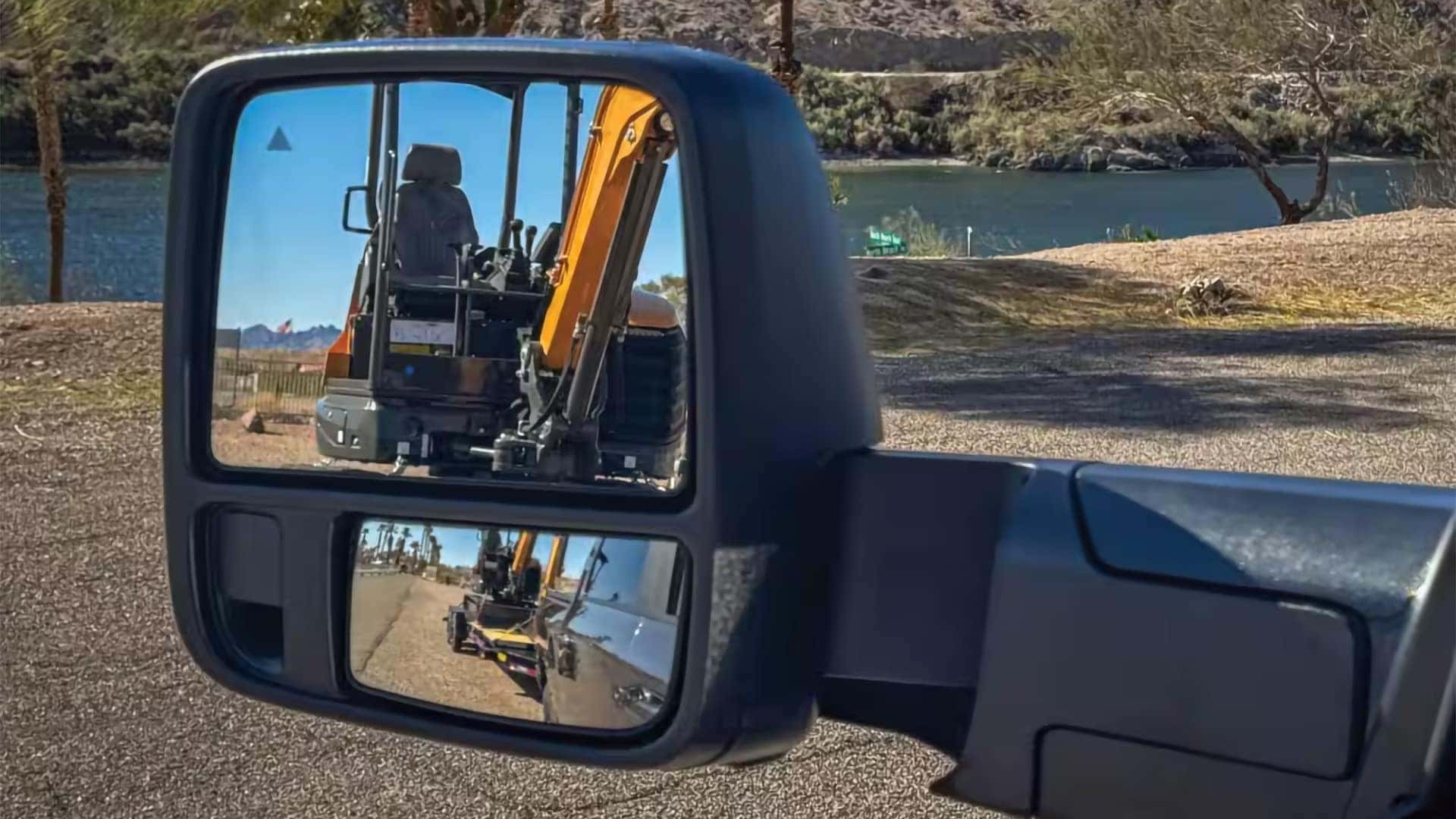 2026 Ram 3500 trailer tow mirror showing rear visibility while hauling construction equipment