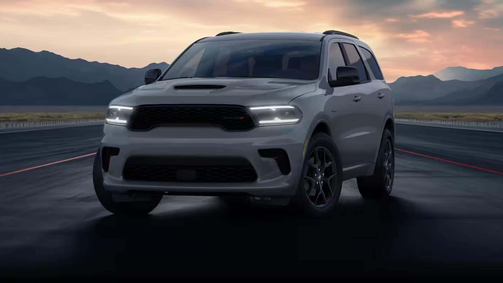 Front three quarter view of the 2026 Dodge Durango parked on a track at sunset highlighting wide stance, LED headlights, and performance SUV design