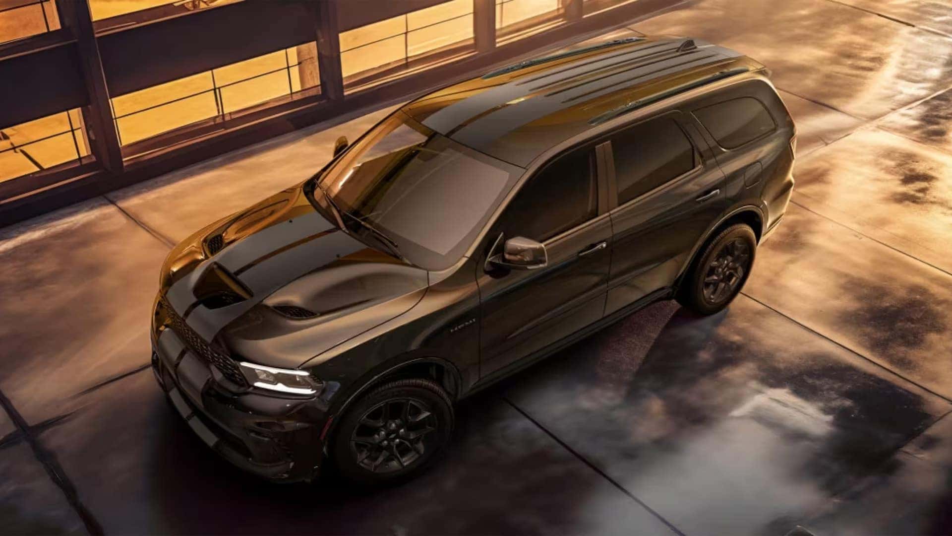 2026 Dodge Durango SRT Hellcat performance SUV parked in warm sunset lighting, high angle view highlighting hood scoop and bold exterior styling