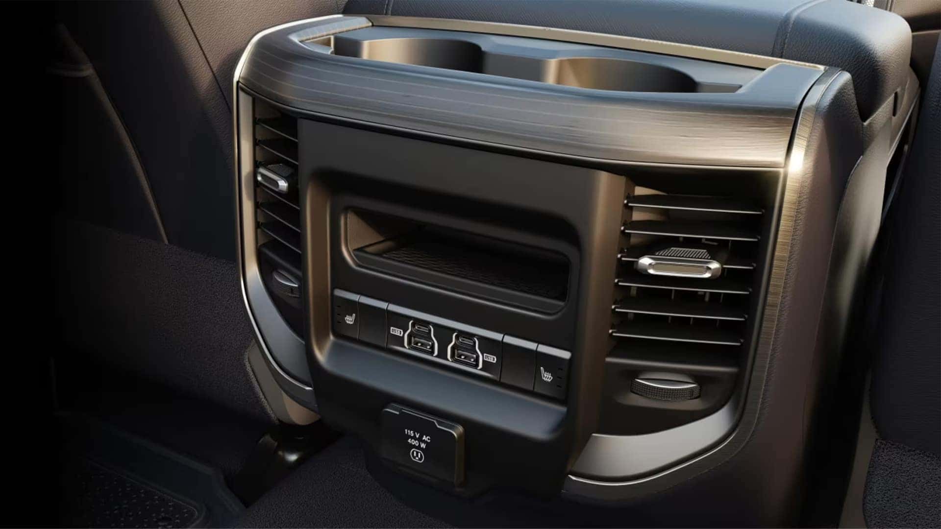 Rear center console in the 2026 RAM 2500 interior with USB ports, power outlet, and climate vents for passengers