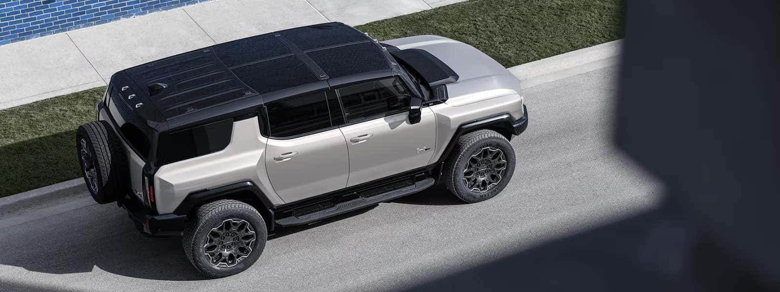 2026 GMC HUMMER EV SUV electric SUV driving on a road, front three quarter view