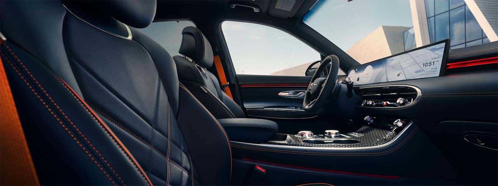 2026 Genesis GV70 interior with sport seats, ambient lighting, and wide OLED display across the dashboard