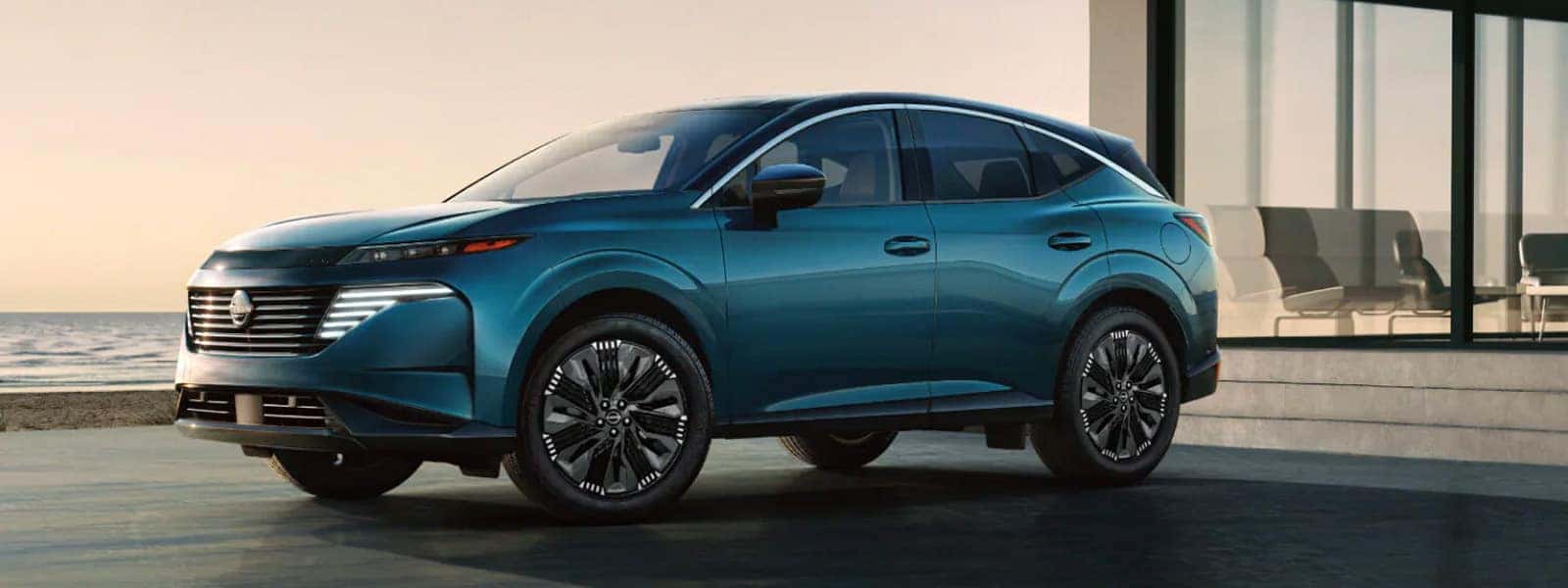 2026 Nissan Murano midsize SUV in teal parked outside a modern building, side profile view