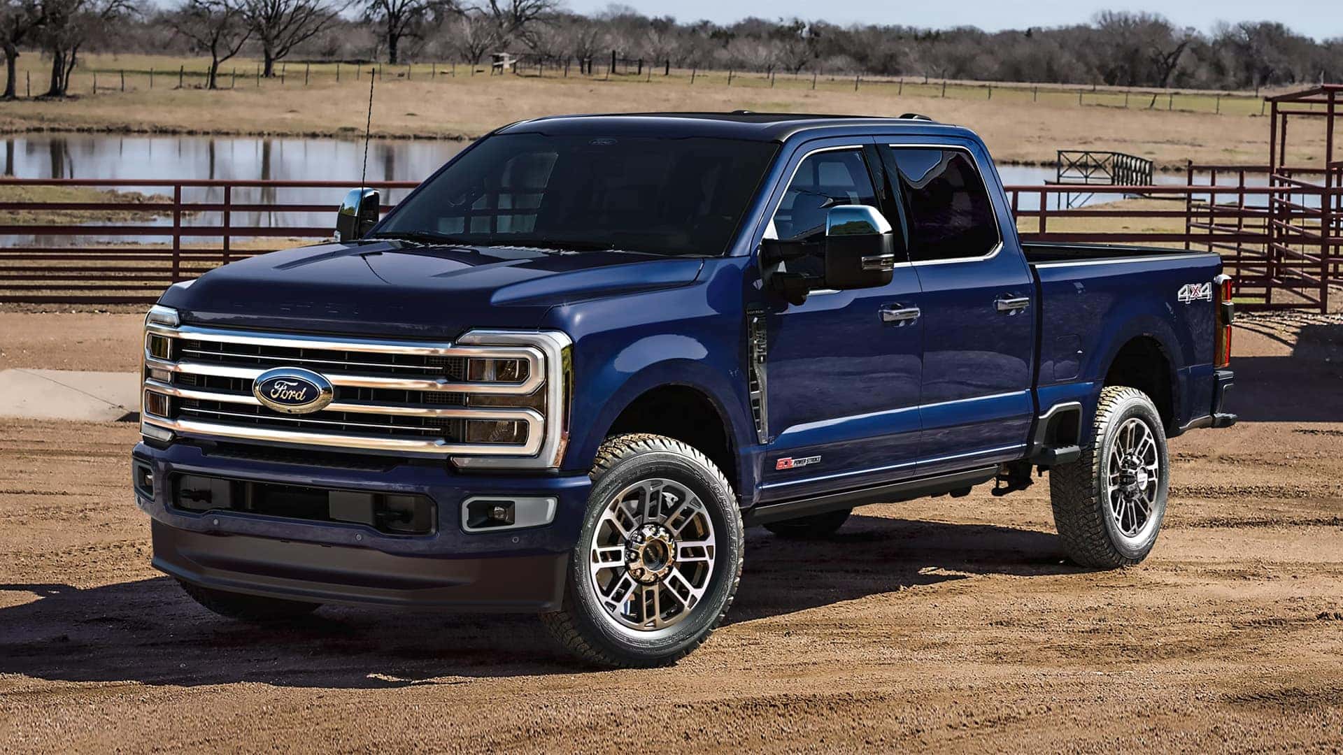 Blue 2026 Ford F-350 Super Duty parked on a ranch road, highlighting exterior design, crew cab size, and heavy duty stance
