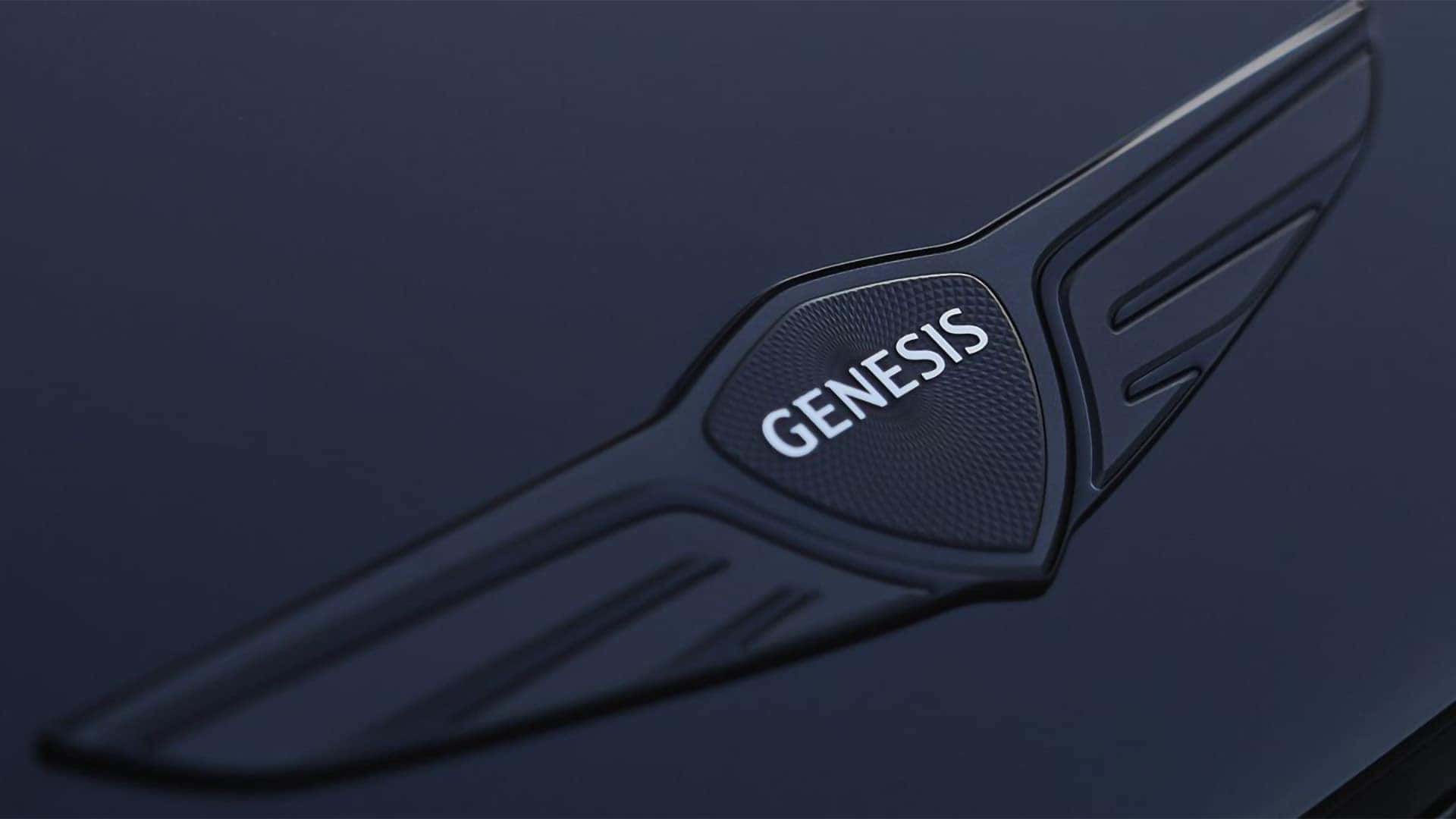 Close up of Genesis wing badge on hood of 2026 Genesis G80 highlighting premium exterior branding detail
