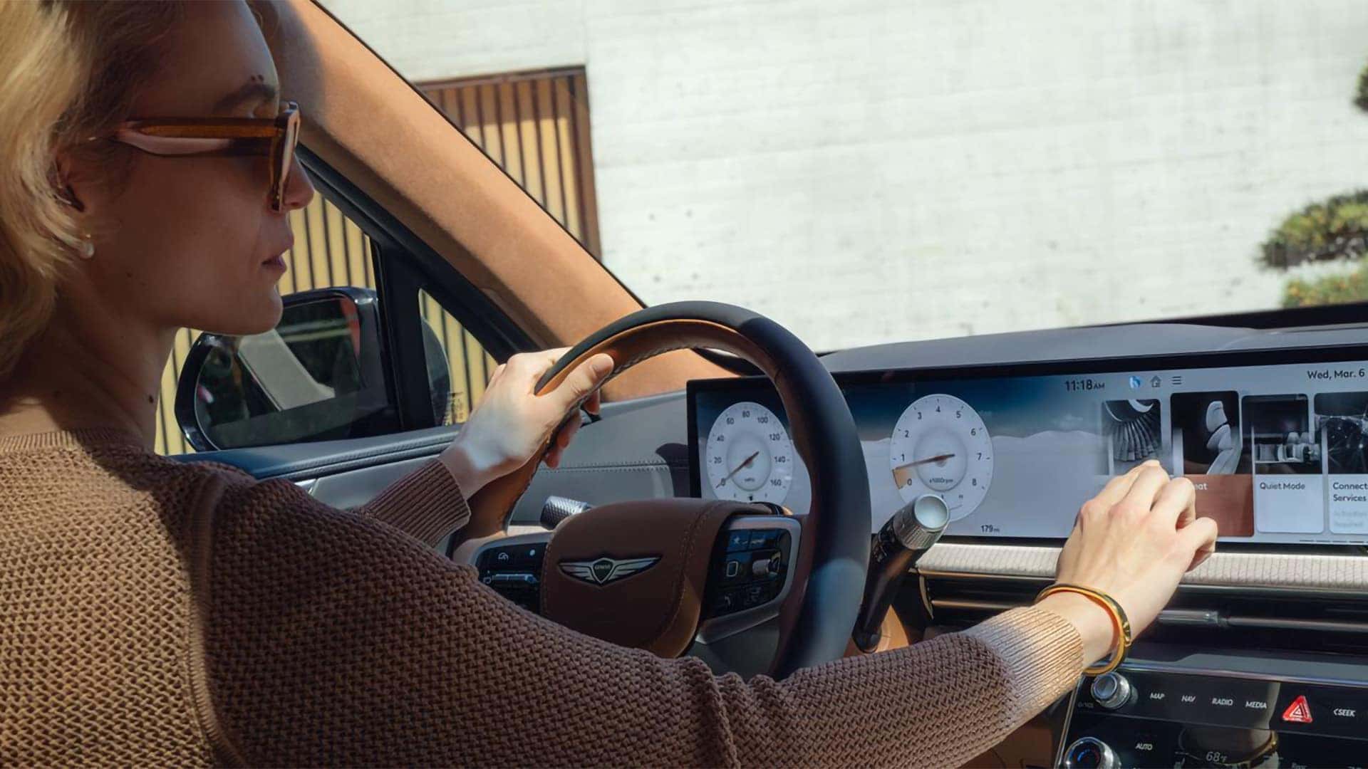 Driver using the 27-inch OLED display inside the 2026 Genesis GV80 luxury SUV