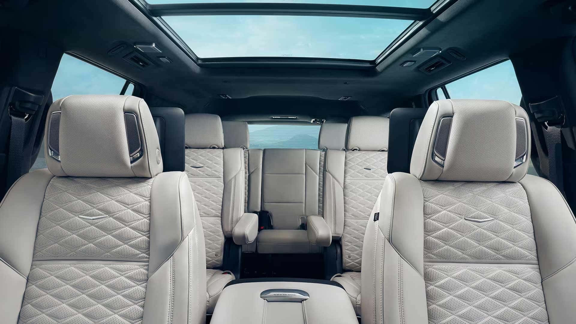 Cadillac Escalade interior with light quilted seats, three rows, and a panoramic glass roof