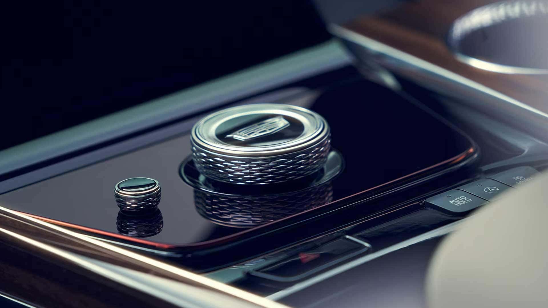Close up of Cadillac Escalade center console controls with rotary dial and gloss trim