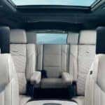 Escalade cabin with light leather seats, diamond stitching, headrest speakers, and glass roof