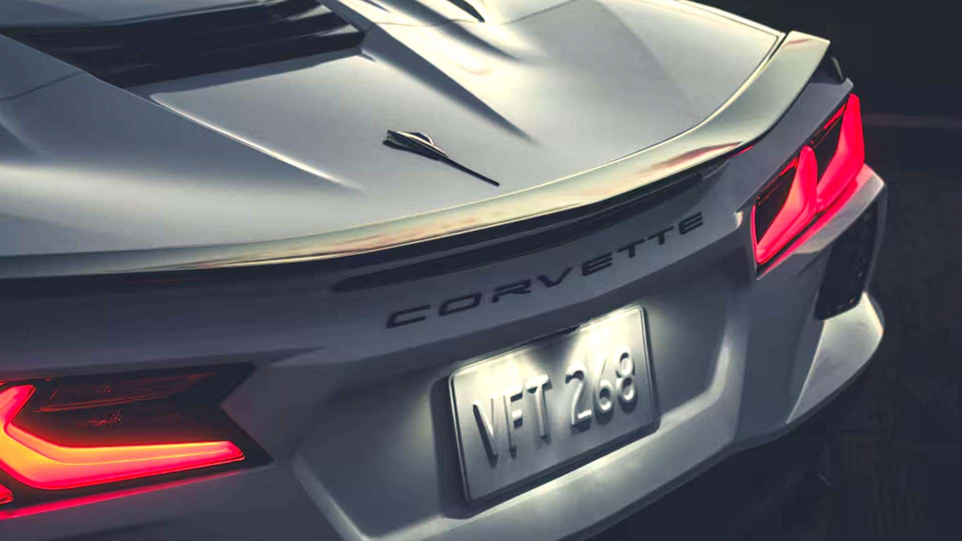 Close-up of a silver Corvette rear section with taillights, rear spoiler, and Corvette lettering.