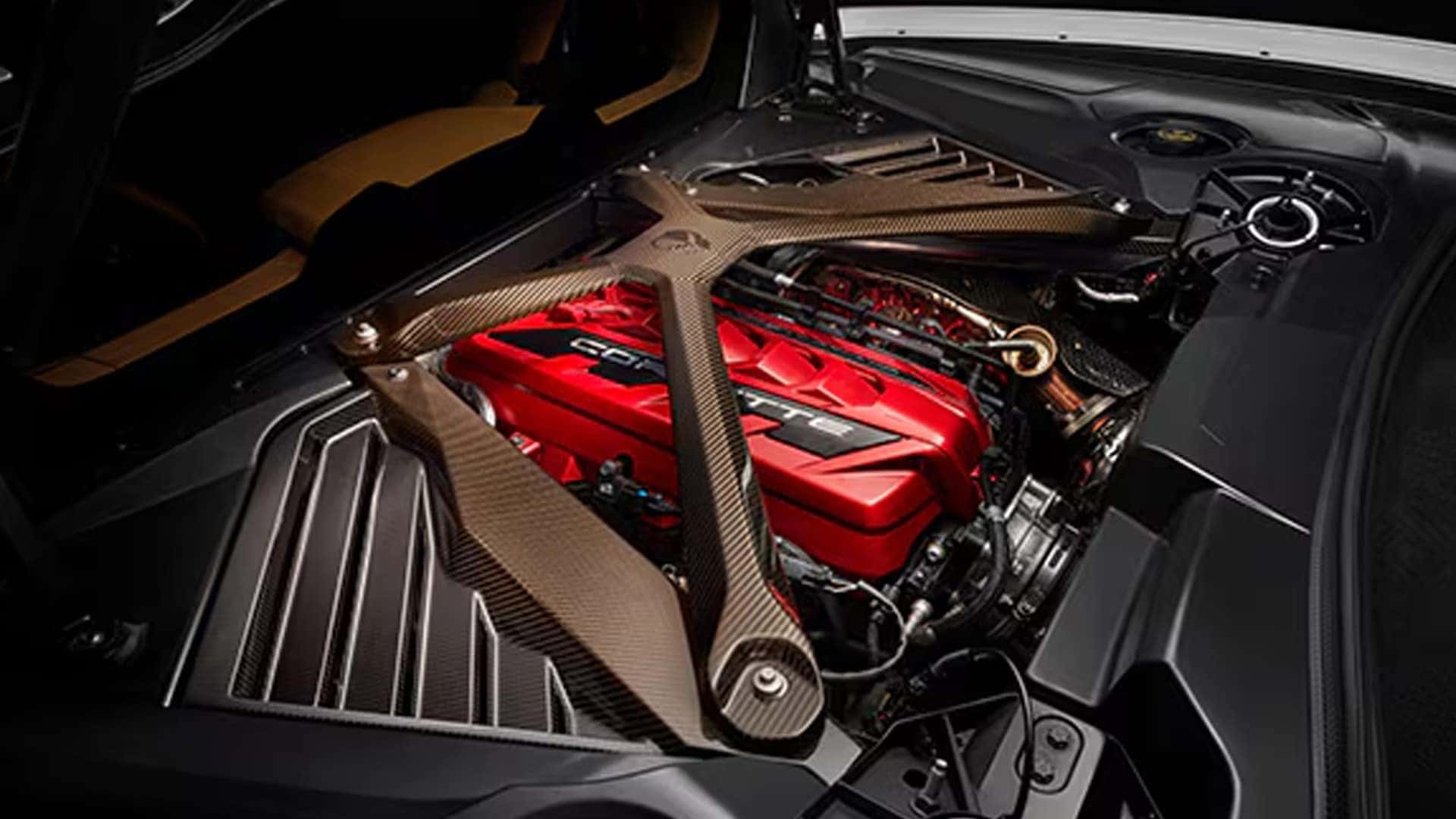 Open engine compartment showing a red engine cover, carbon-look brace, vents, and surrounding panels