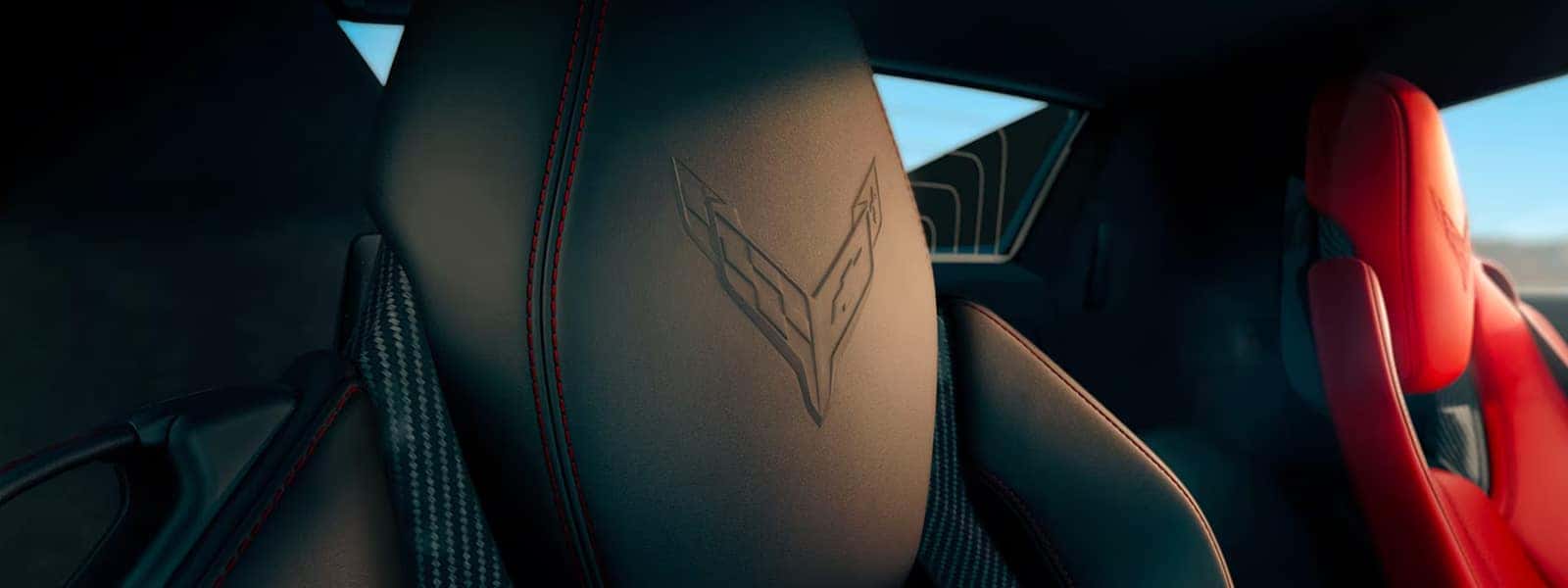 Close-up of Corvette seatbacks with black and red leather, red stitching, and Corvette logos.