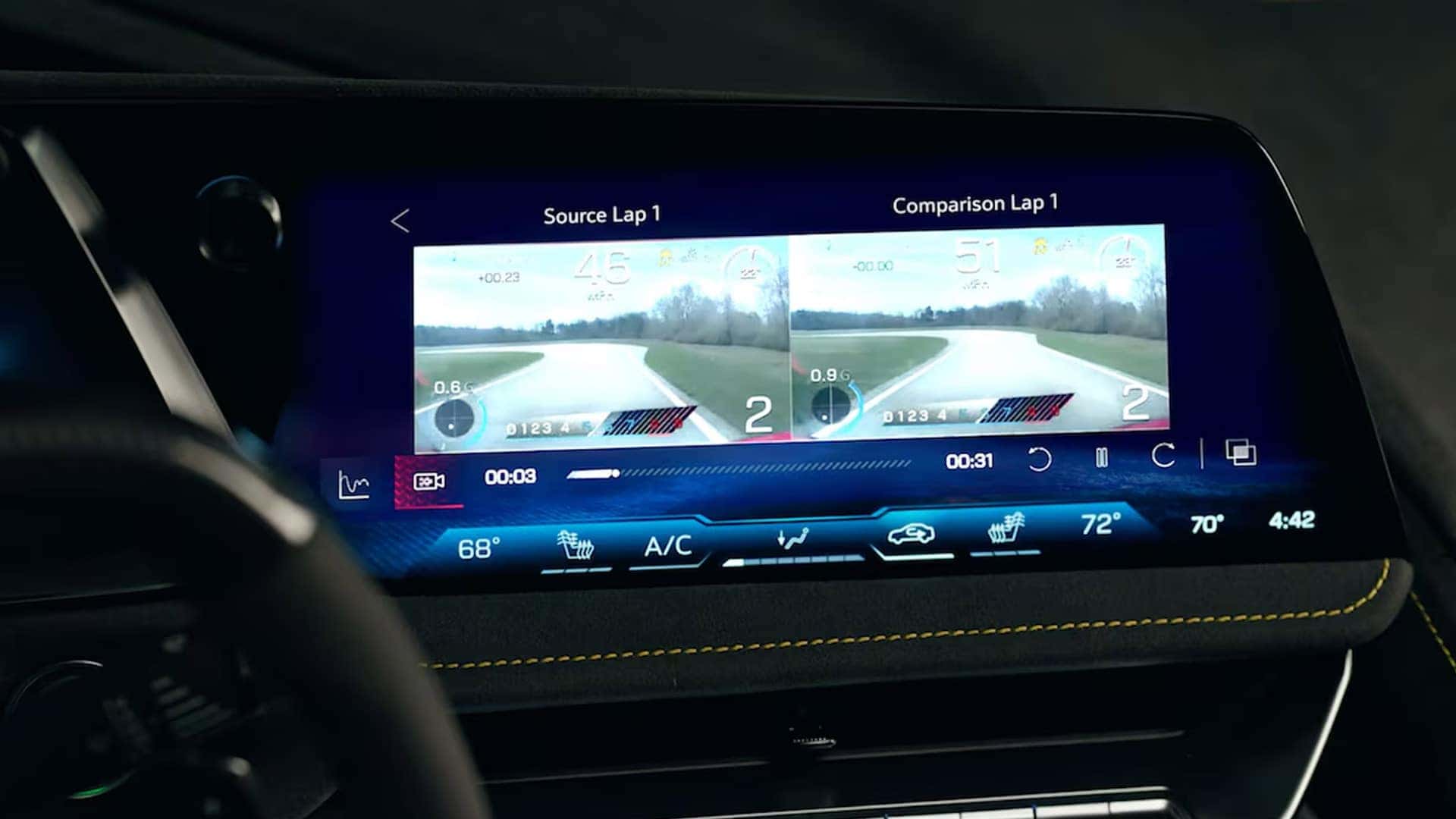 Corvette touchscreen showing split-screen lap comparison video with climate controls below.