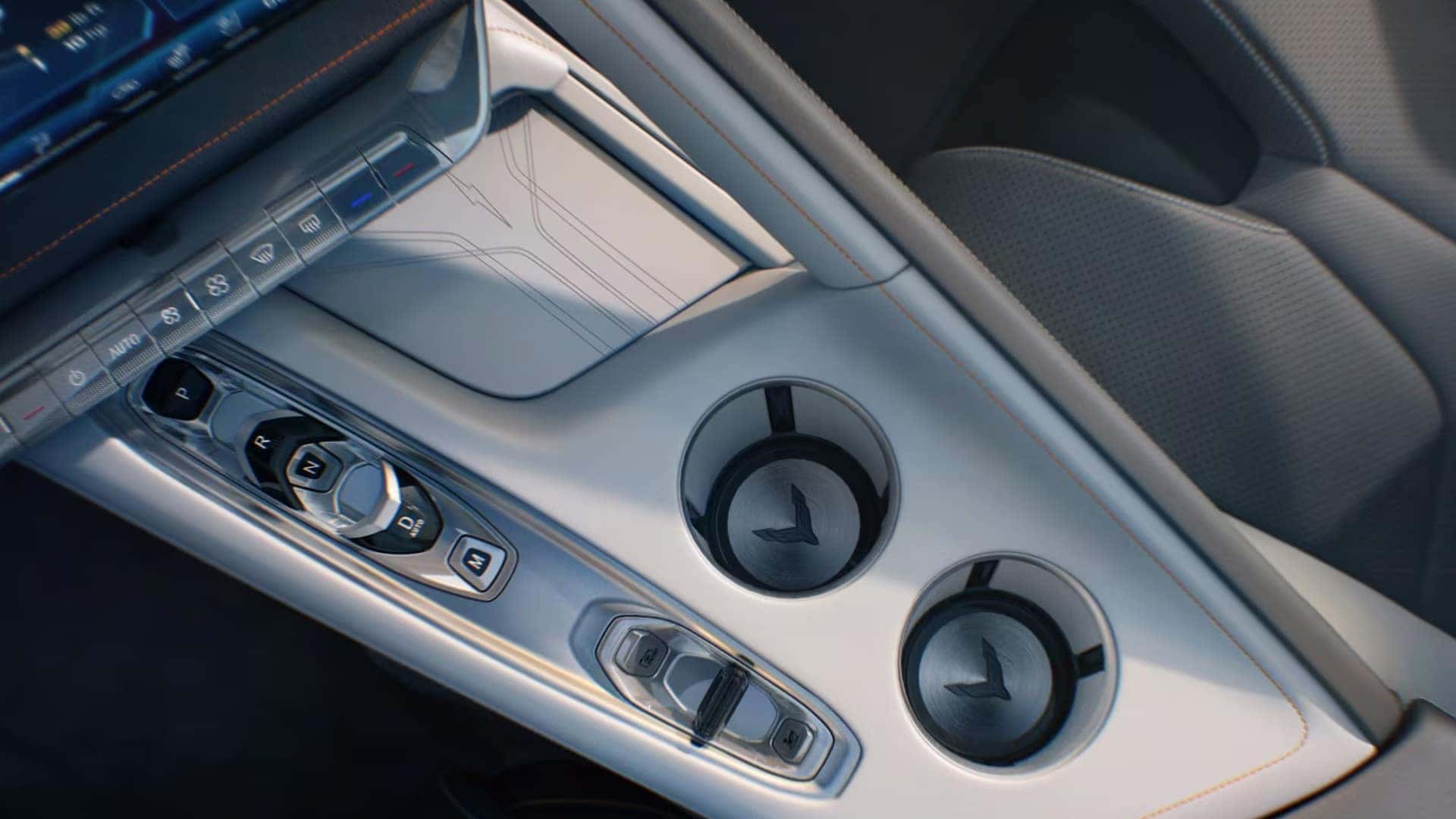Close view of a center console with gear buttons, two cupholders, and climate controls.