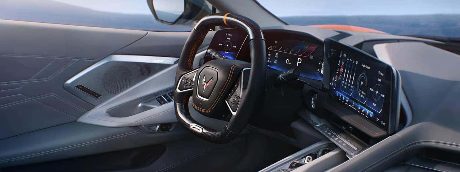 Wide dashboard view with steering wheel, digital gauge cluster, center touchscreen, and door speaker.