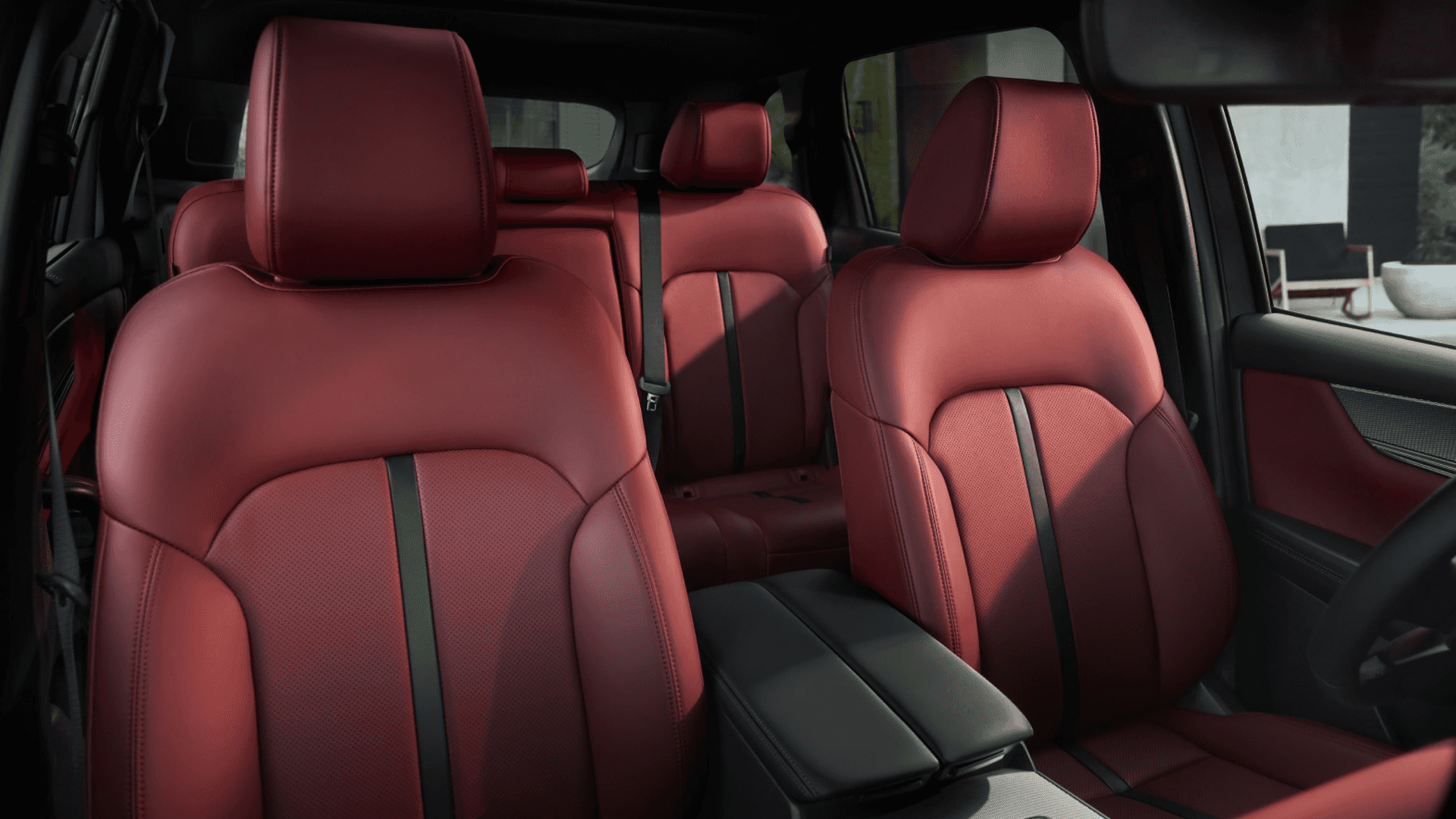 Red leather front and rear seats with center armrest and black accents visible across the cabin