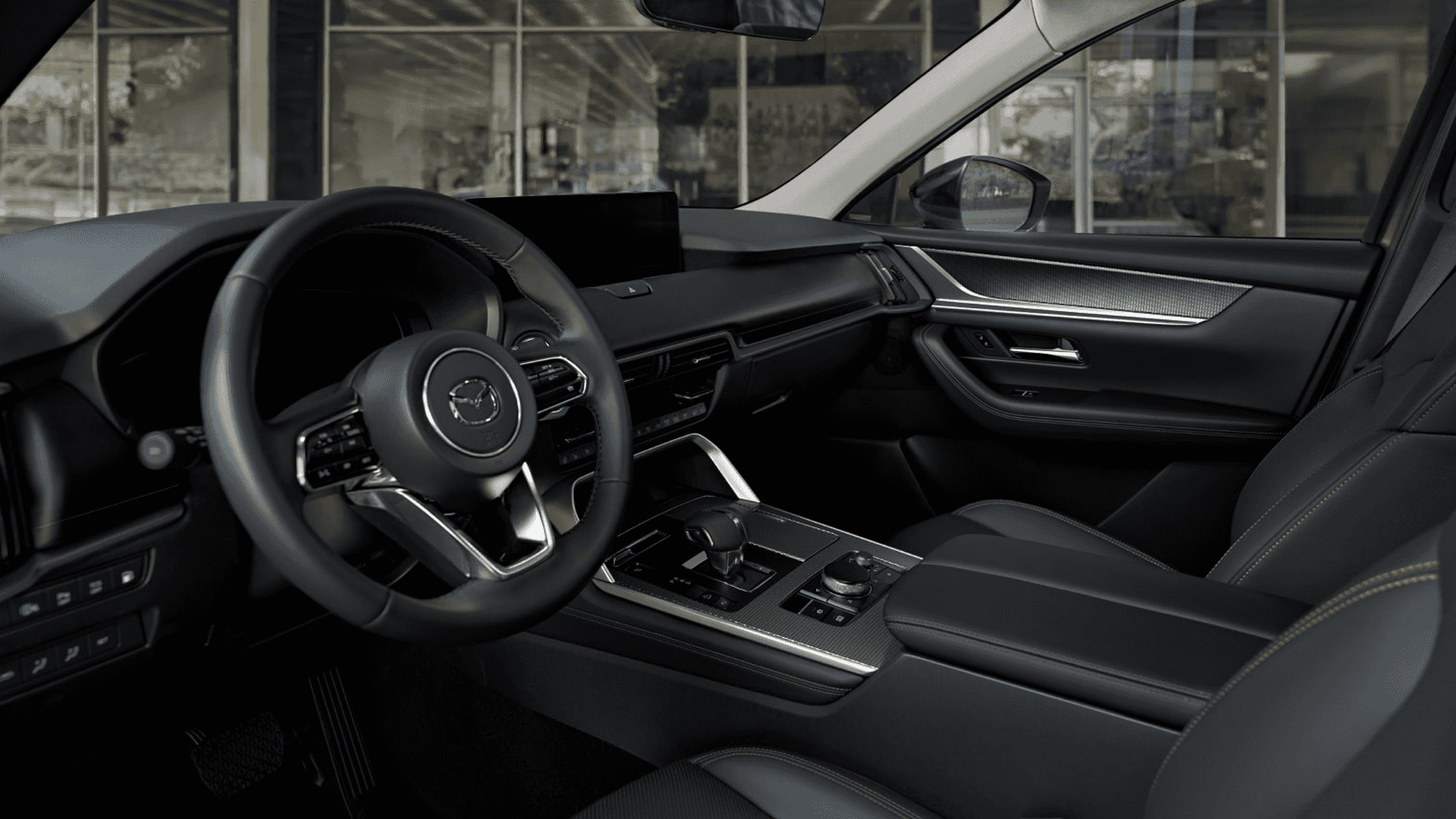Front cabin with black seats, steering wheel, center console controls, and metallic interior accents