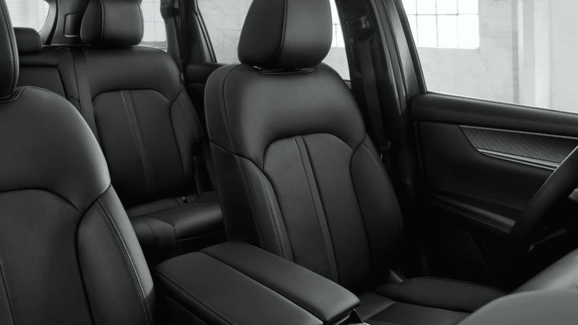 Front seats in black upholstery with center armrest and stitched detailing visible across seating surfaces