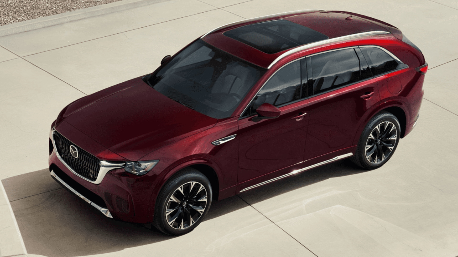 Red 2026 Mazda CX-90 from a high front three-quarter angle, showing full body shape, roofline, and side glass