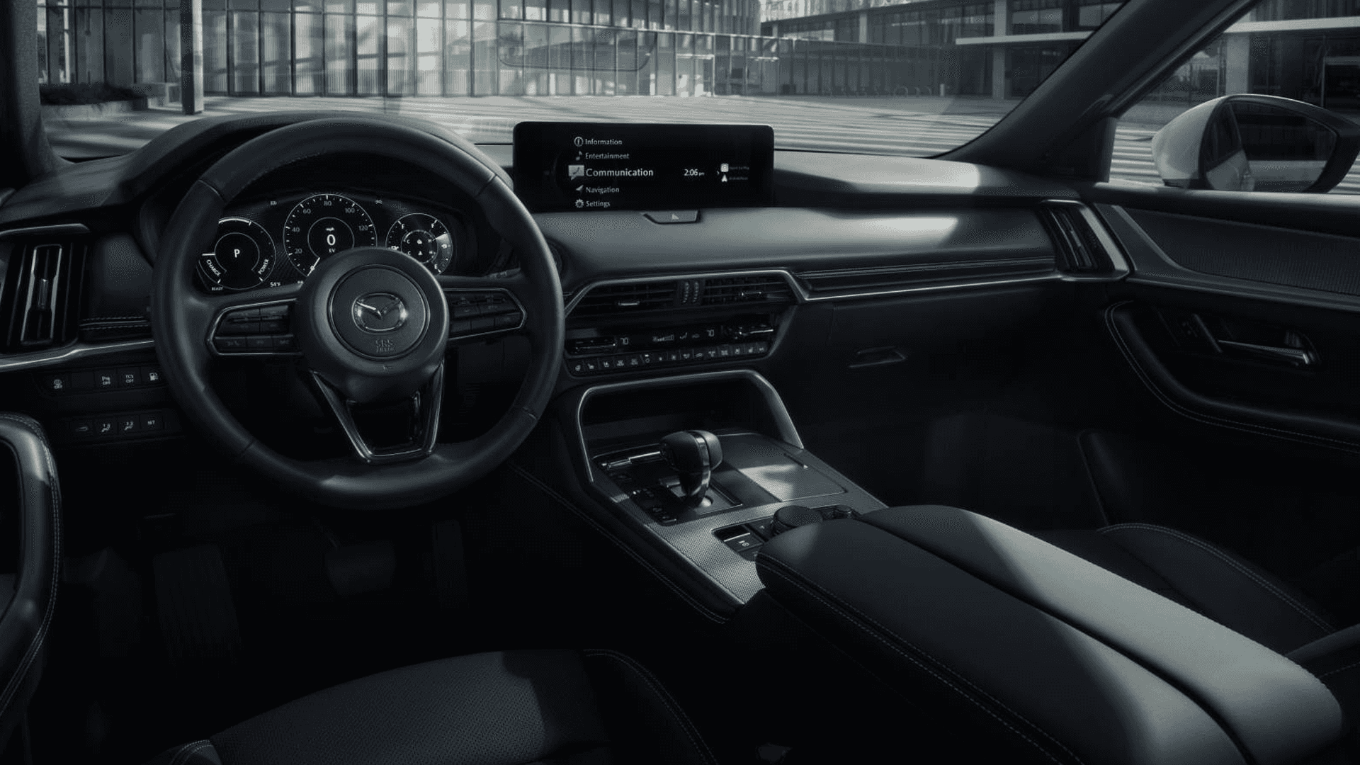 Mazda CX-90 driver cockpit with steering wheel, digital gauge cluster, center display, and center console controls