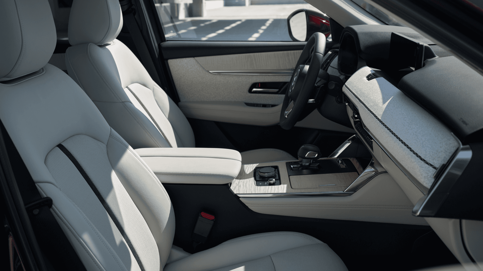 Front passenger area with light seats, center console, dashboard trim, and steering wheel seen from the side