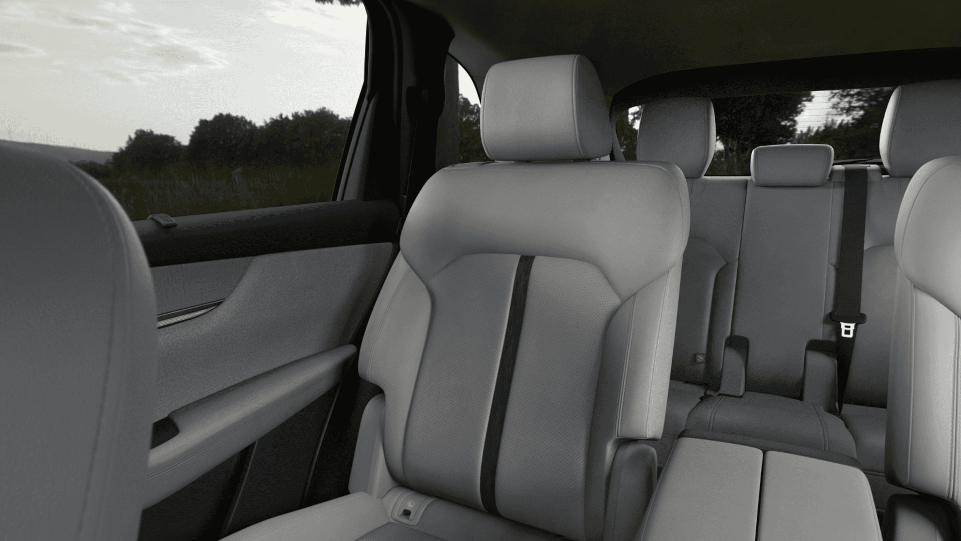 Second-row captain's chairs in light upholstery with armrests, plus a visible third-row bench behind them
