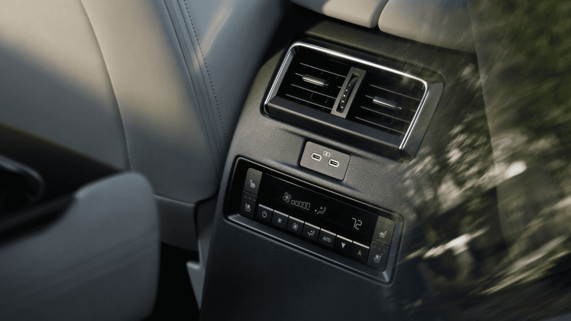 Rear seat area with air vents, USB-C charging ports, and climate control panel showing temperature settings.