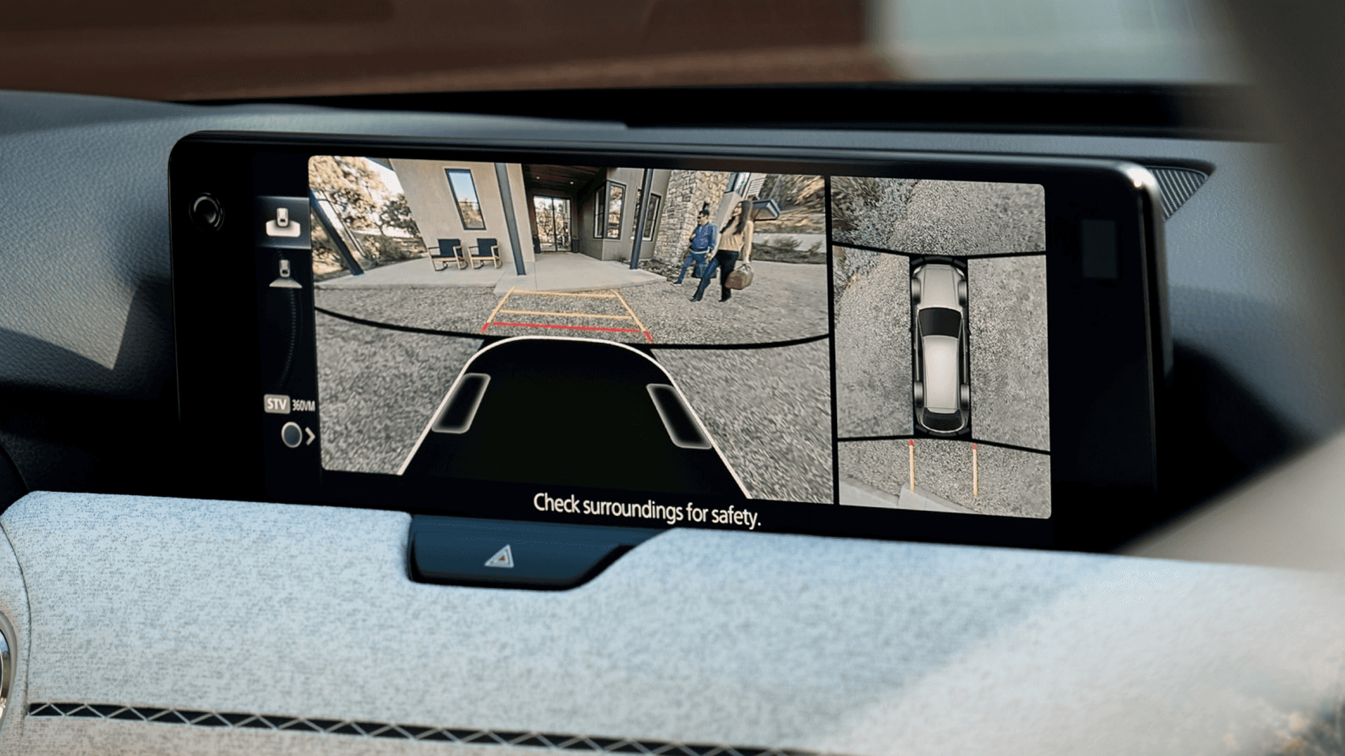 Wide center display showing split camera views including rear view and top-down parking perspective.