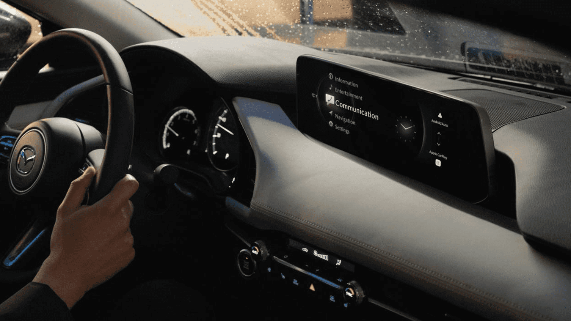 Mazda3 interior with wide dashboard display showing communication menu, Apple CarPlay, and Android Auto.