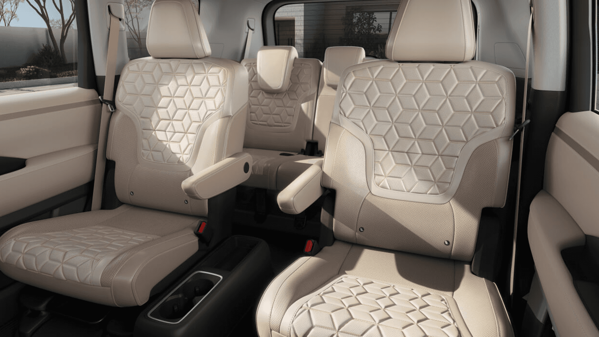 Beige interior seating of Nissan Armada showing two front seats and second row seats with patterned upholstery