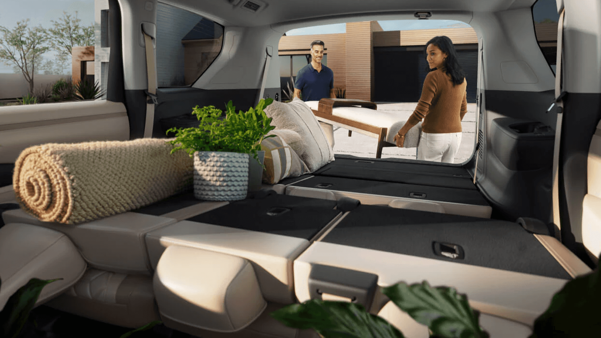 Rear cargo area with folded seats and household items, viewed from inside looking toward open tailgate