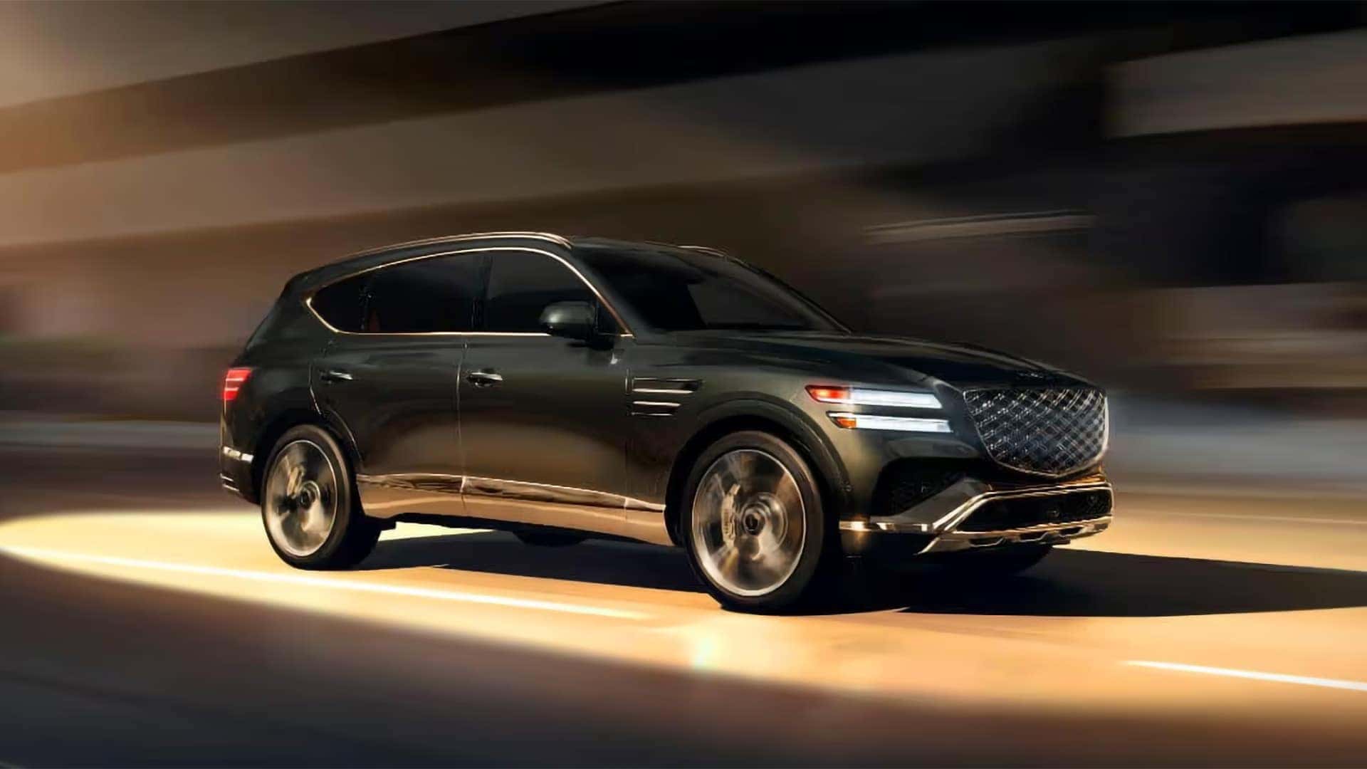 2026 Genesis GV80 driving at night with signature two line LED headlamps and illuminated front design