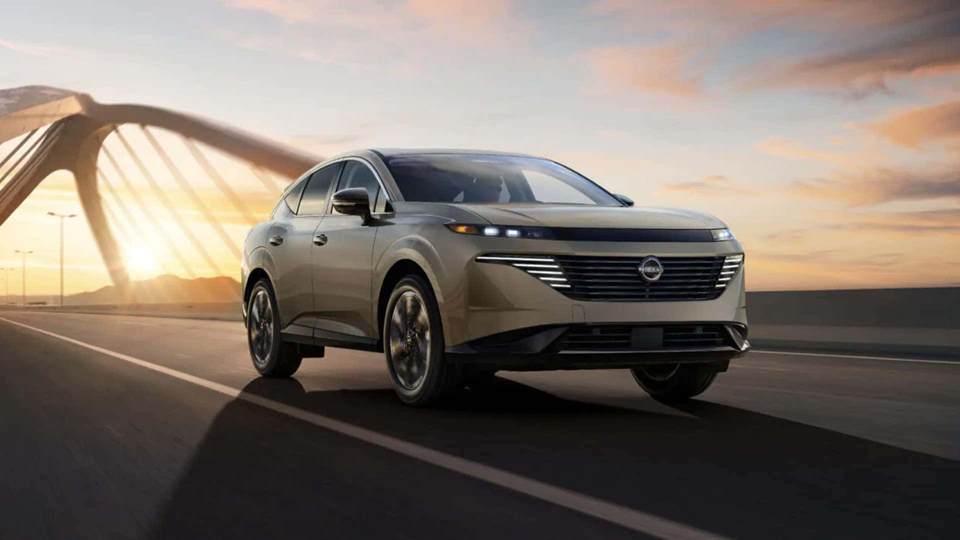 2026 Nissan Murano driving across bridge at sunset with slim LED lighting, bold grille, and sleek front end styling