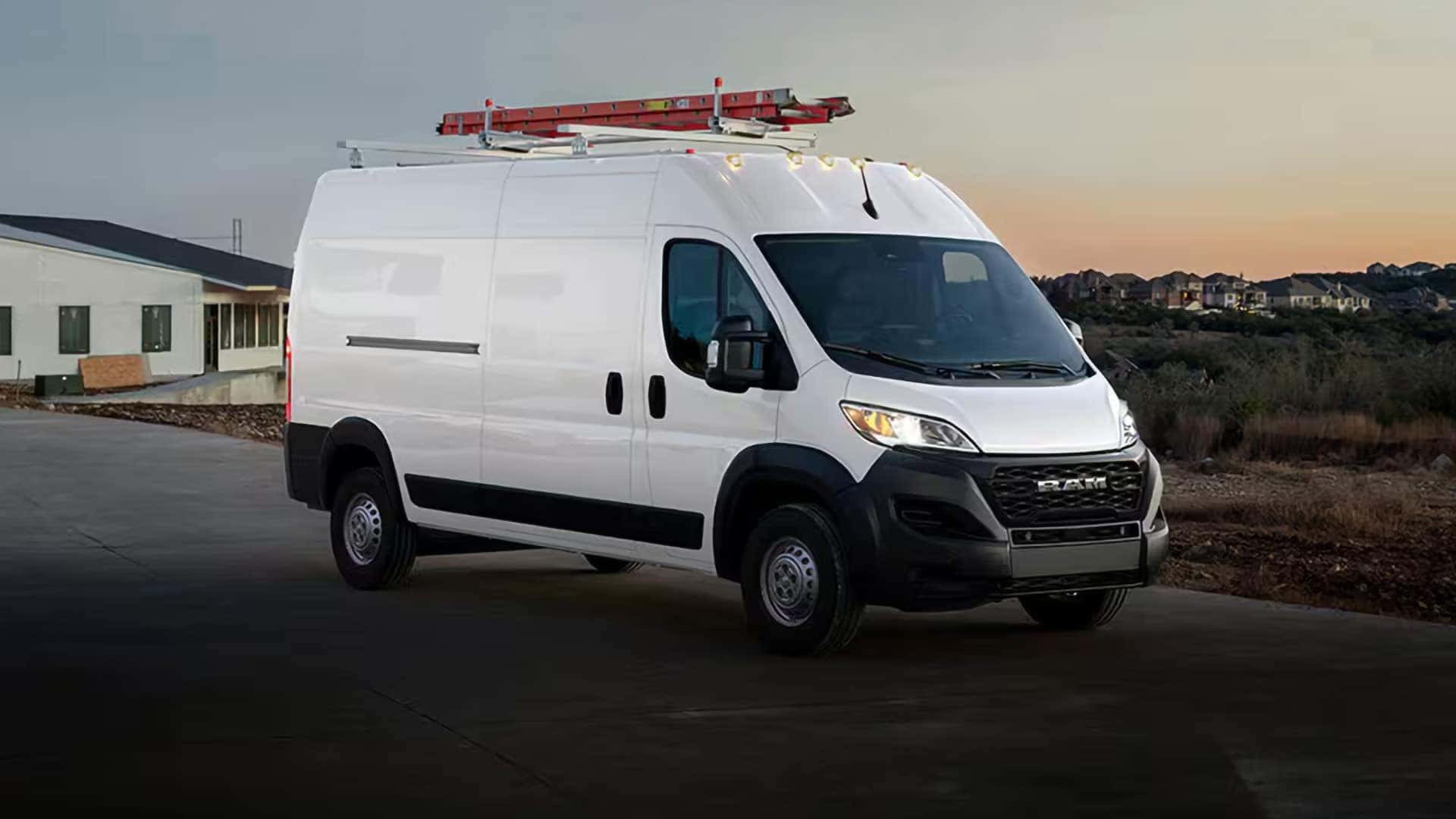 2026 RAM ProMaster Cargo Van driving at sunset with headlights on and roof mounted equipment