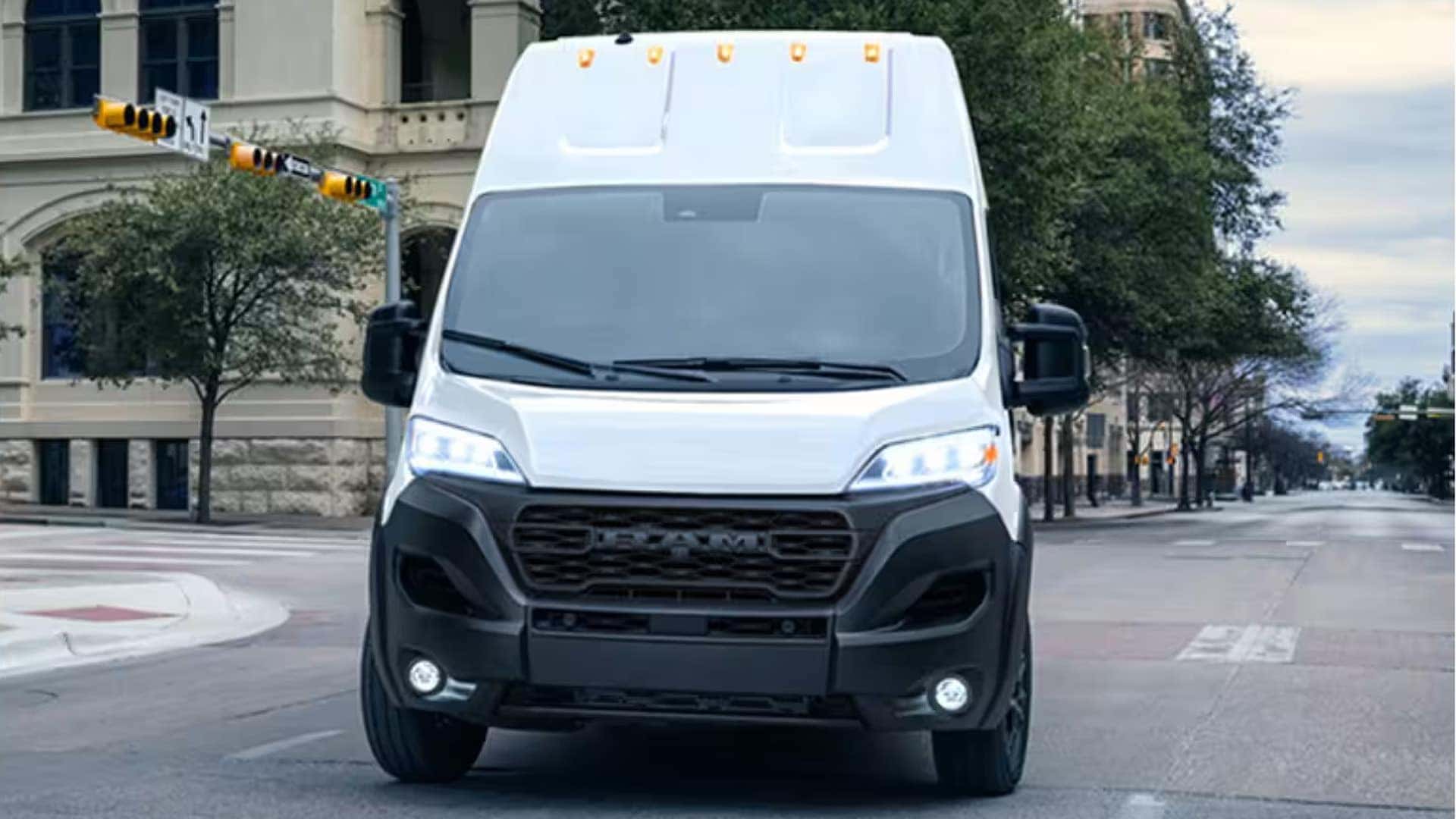 Worker organizing tools and equipment inside a 2026 RAM ProMaster Cargo Van with built-in shelving