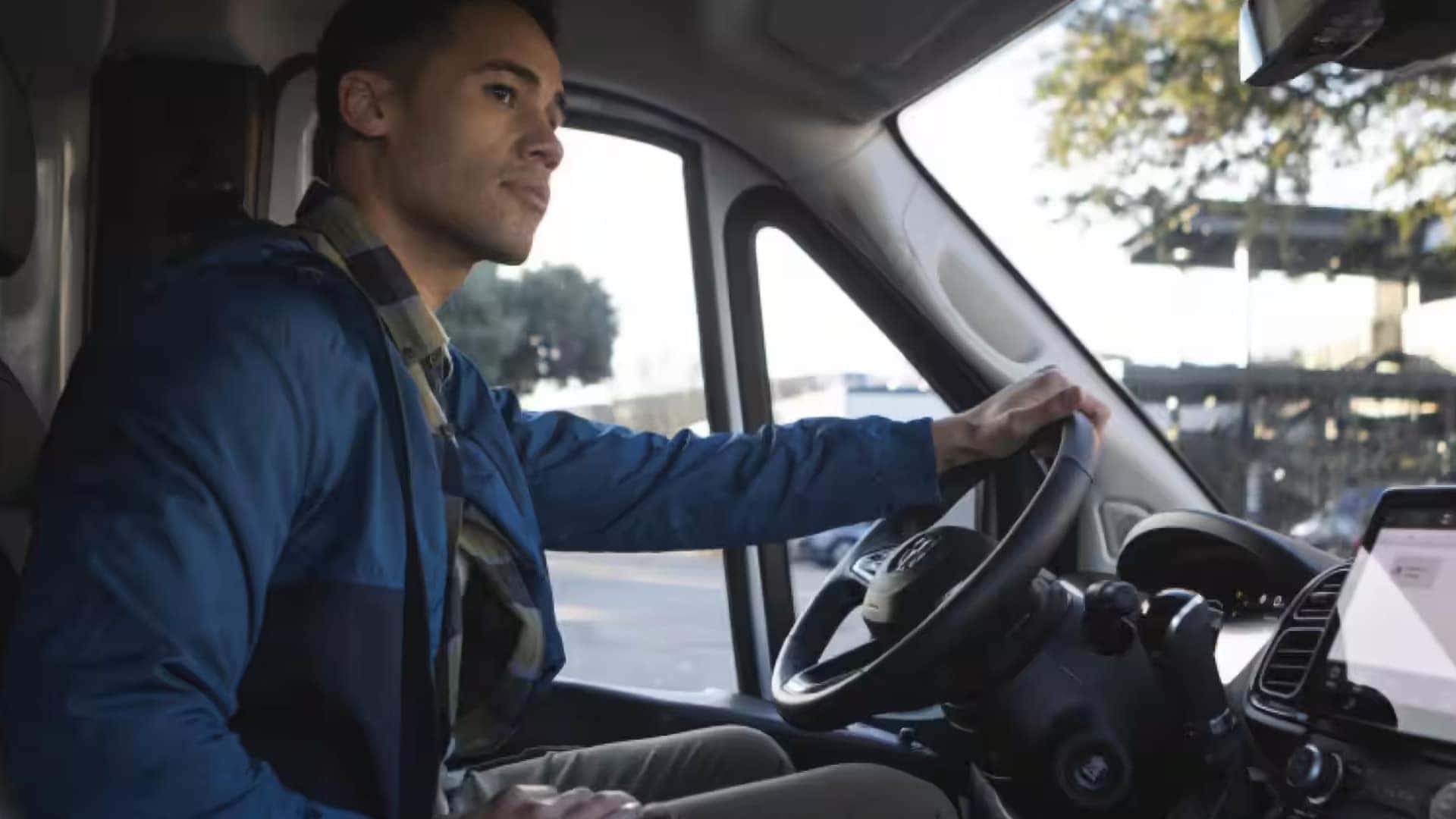Driver inside the 2026 RAM ProMaster Cargo Van cabin with hands on the steering wheel